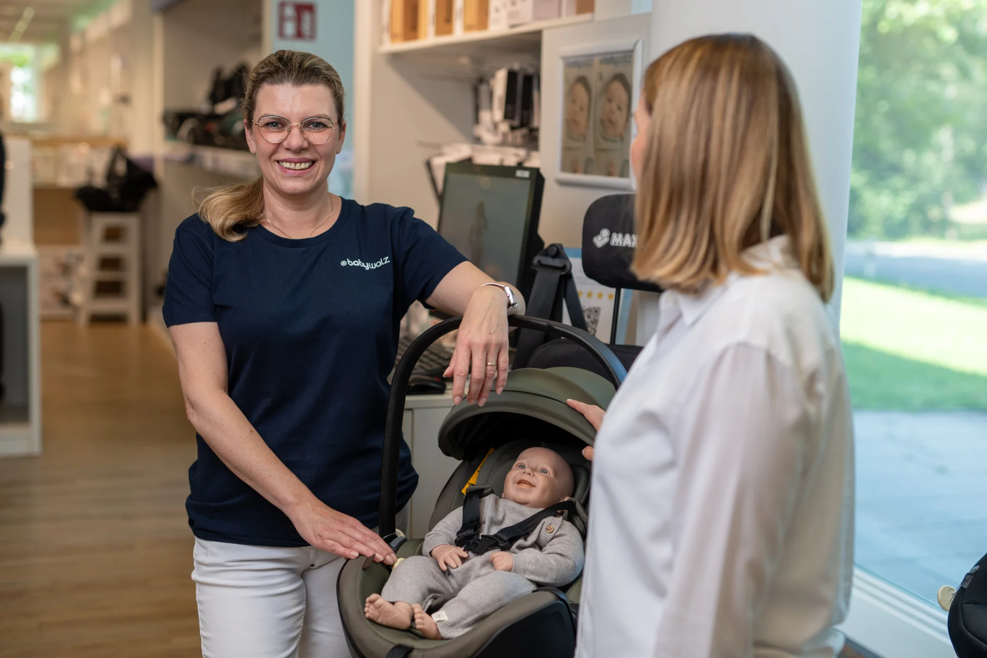 baby-walz Mitarbeiterin berät eine Kundin am Kinderwagen